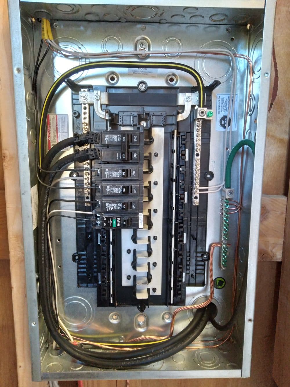 Electrical breaker panel with multiple circuit breakers and wiring connections.