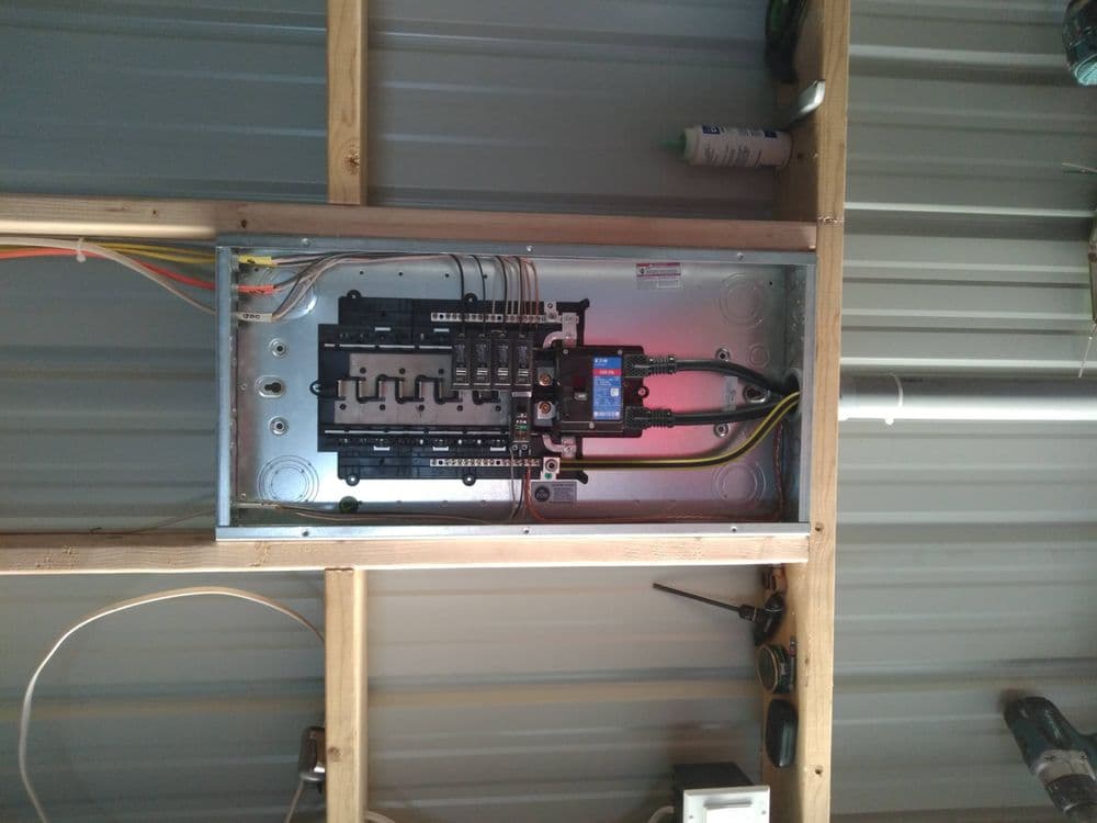 Electrical panel installation in a metal building showcasing circuit breakers and wiring.