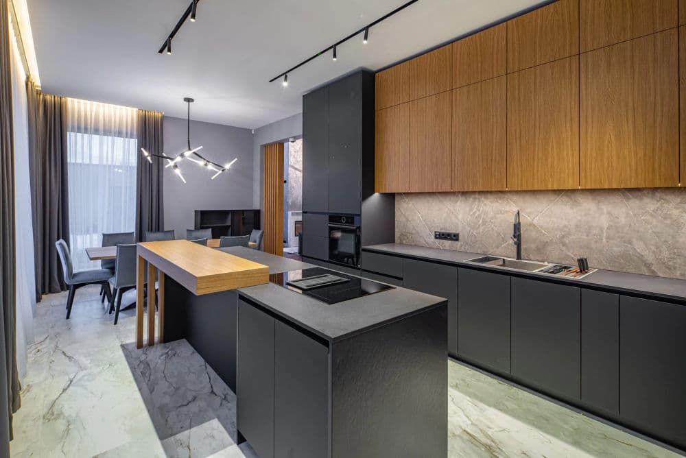 Modern kitchen design featuring sleek black cabinetry, wooden accents, and marble flooring.
