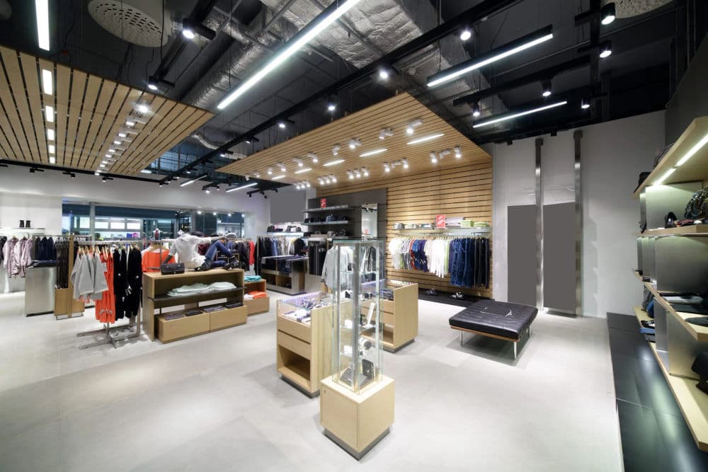 Modern retail store interior showcasing clothing racks, accessories, and display cases.
